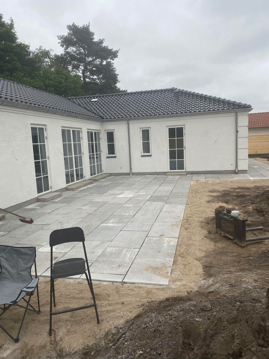 Stor terrasse med betonbelægning ved nyt byggeri i Allerød af Haarkjær Byg