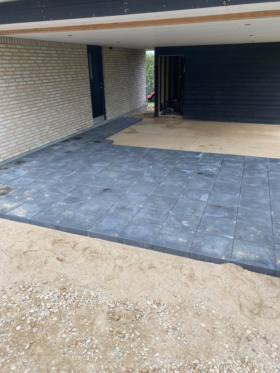 Mørk betonbelægning i carport ved nyt byggeri i Hillerød af Haarkjær Byg