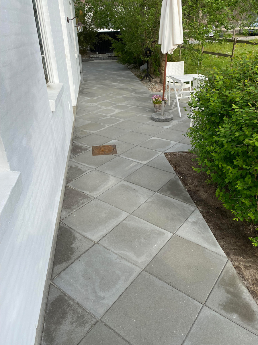 Flisegang med betonbelægning langs bondehus i Hørsholm af Haarkjær Byg